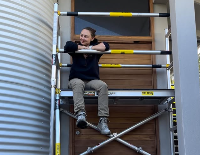 The Paint Chic, Krysral, Sitting on scaffolding out the front of a home
